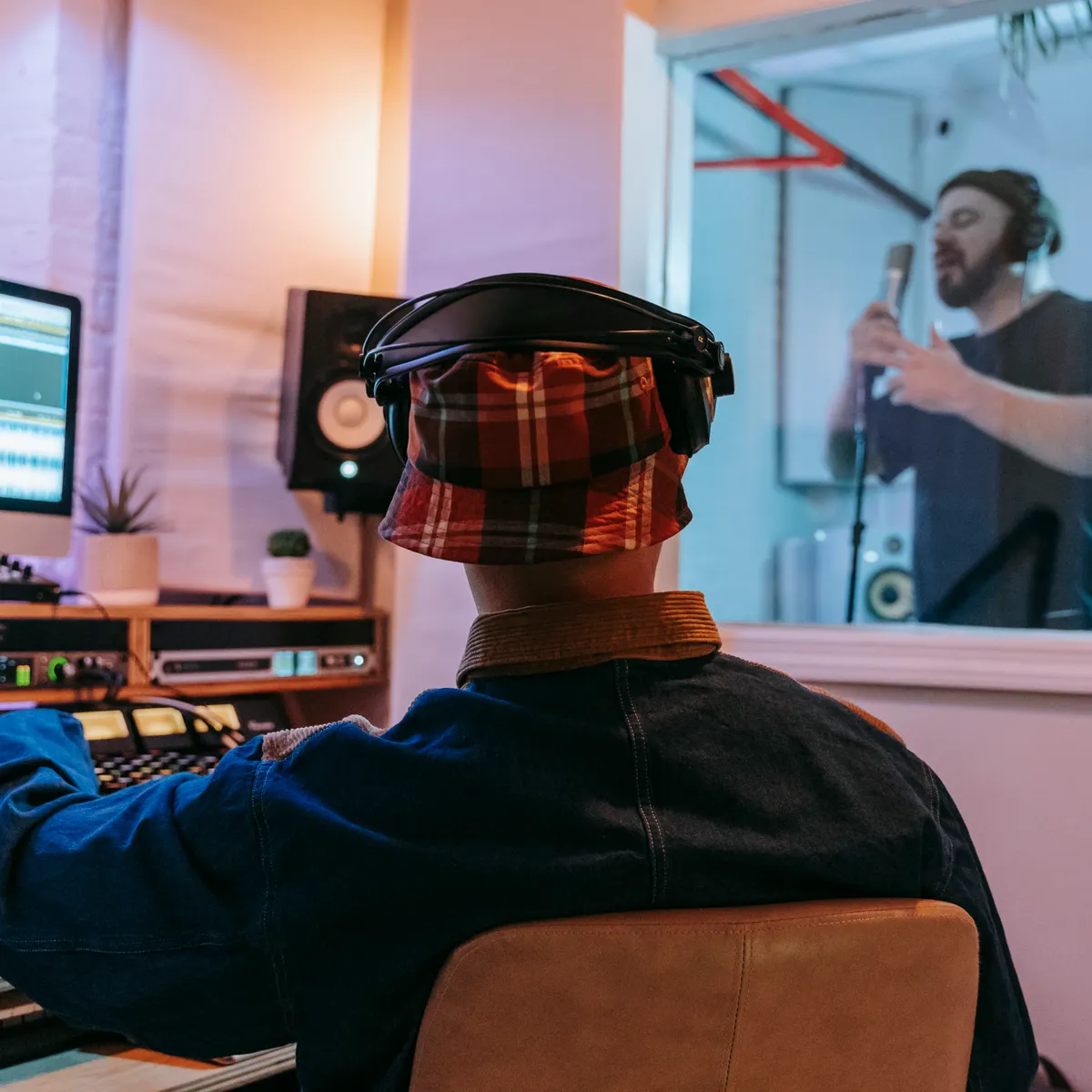 Musician and producer working together in a professional recording studio